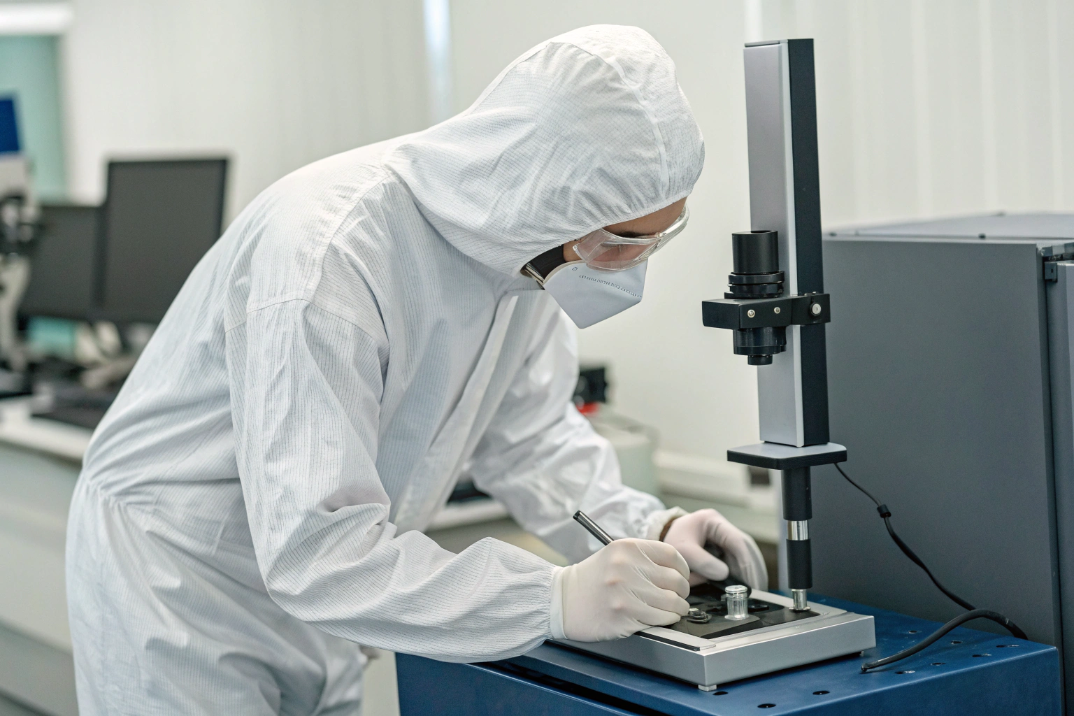 Cleanroom inspection Technician in cleanroom suit inspecting precision parts