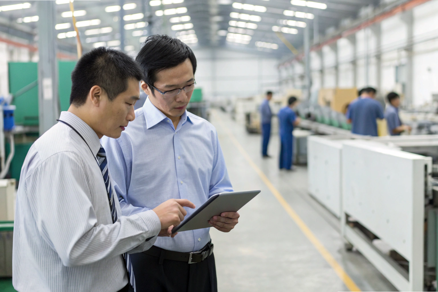 Production meeting Managers discussing production data on digital tablet