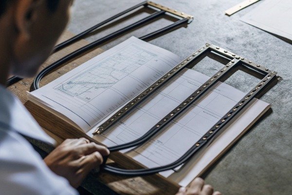 Professional reviewing technical drawings on table (ID#1)