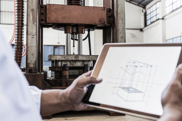 Engineer examining press part with tablet (ID#3)