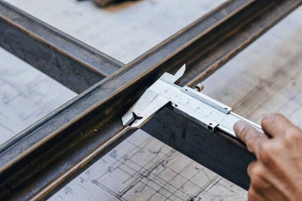 Close-up of caliper measuring metal weld joint (ID#3)