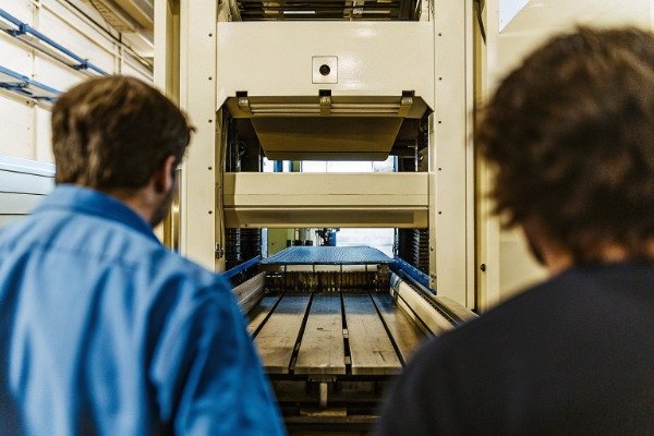 Workers inspecting automated stamping machine (ID#3)
