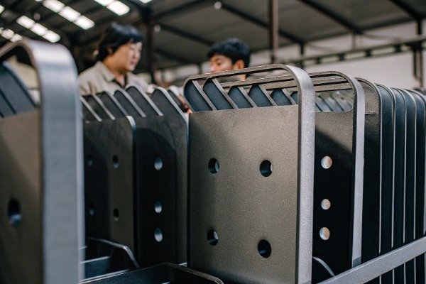 Workers inspecting custom metal parts in factory (ID#3)