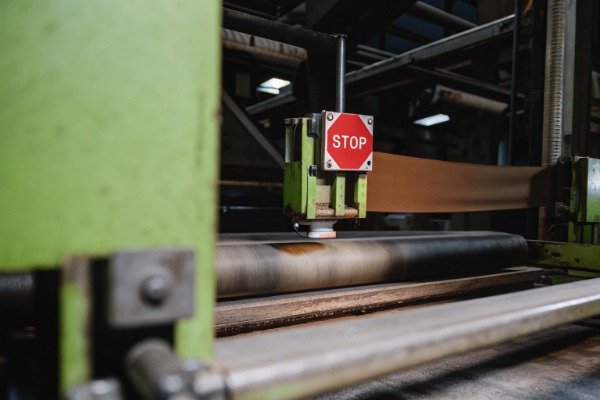 Industrial factory production line featuring a prominent red emergency stop safety sign (ID#5)