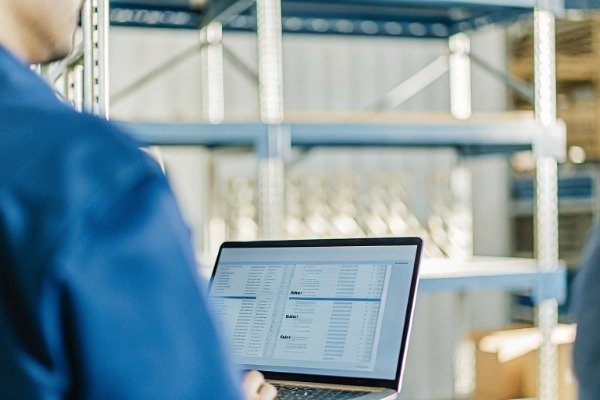 Person using laptop in a modern manufacturing office space (ID#5)