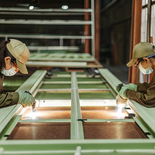Workers assembling metal frames in factory (ID#1)