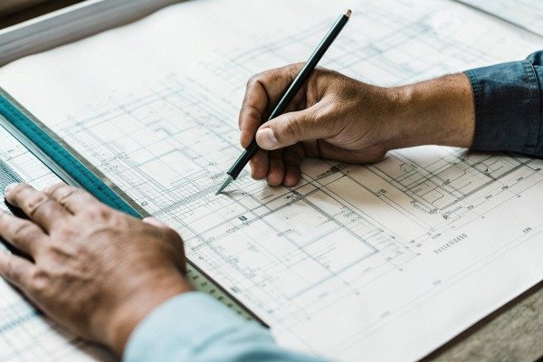 Hands drawing architectural blueprint with ruler (ID#3)