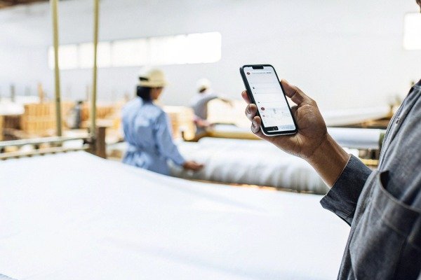 Person using smartphone in factory setting (ID#2)