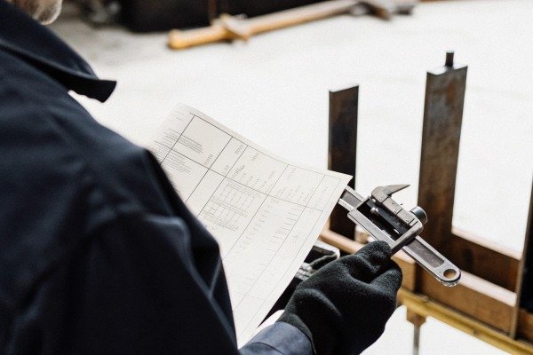 Person holding paper and wrench on site (ID#5)