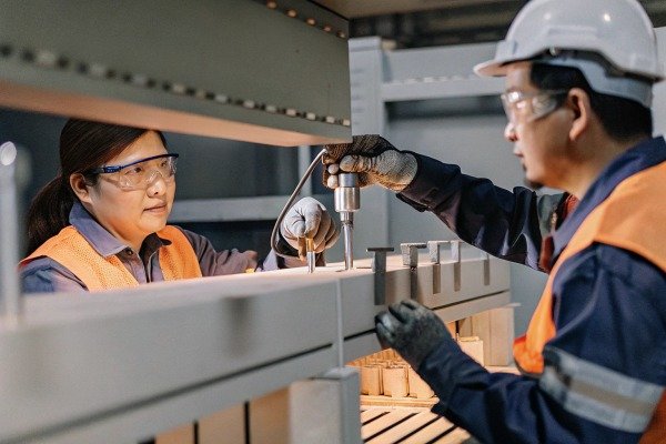 Workers inspecting metal structure with tools (ID#5)