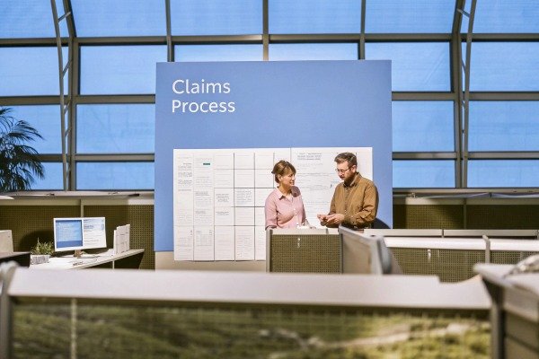 Two people discussing claims process at office (ID#5)