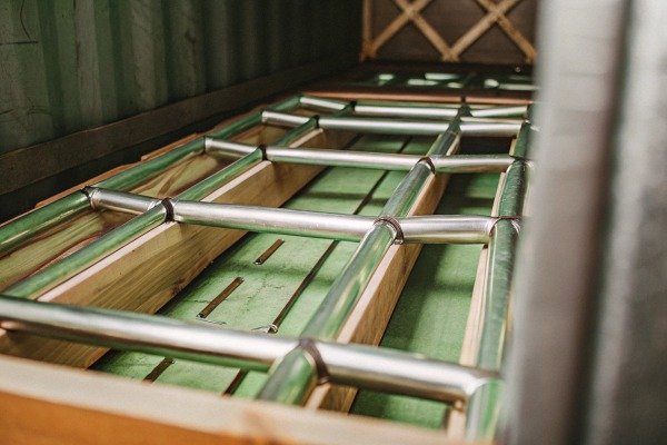 Metal pipes stacked in wooden crate (ID#2)