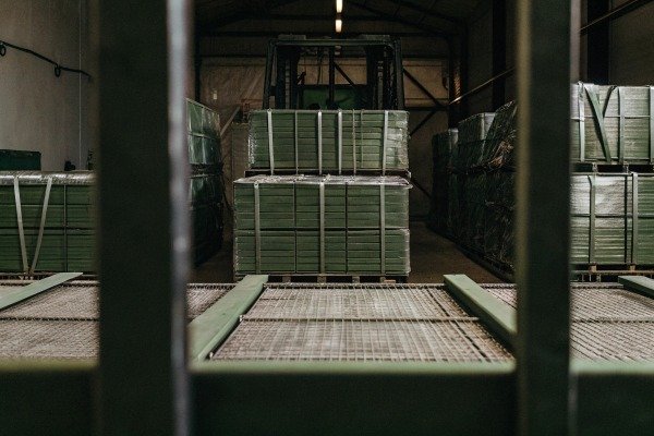 Forklift behind metal bars with stacked pallets (ID#5)