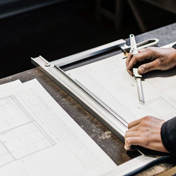 Hands working on technical drawing with ruler (ID#1)