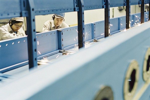 Workers welding blue metal structure indoors (ID#2)