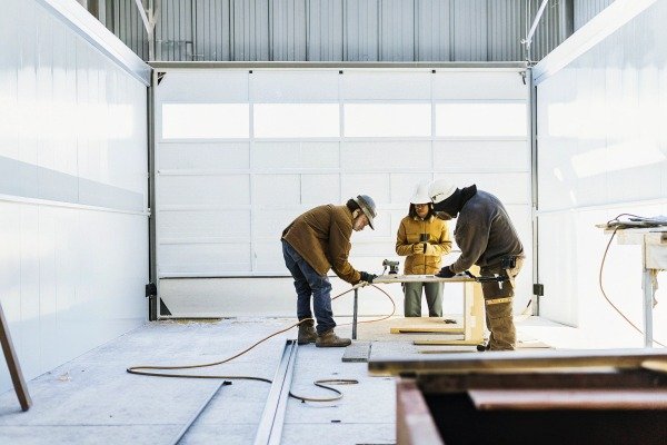 Three workers collaborating in workshop space (ID#5)