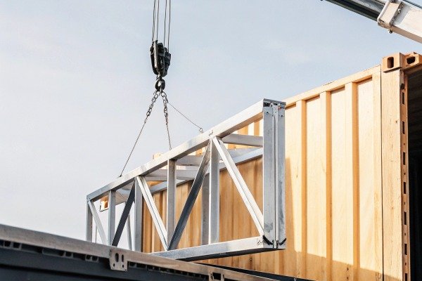 Metal frame being lifted by crane outdoors (ID#2)