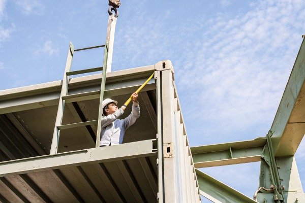 Worker measuring steel structure on container (ID#4)