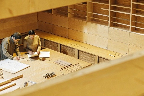 Two people reviewing wooden design plans (ID#3)