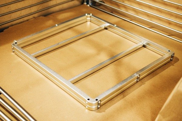 Metal frame component on wooden surface (ID#5)