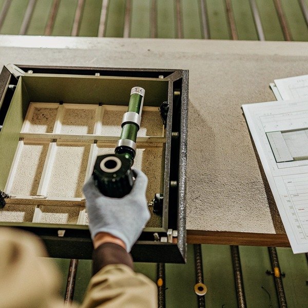 Worker inspecting component in metal frame (ID#1)