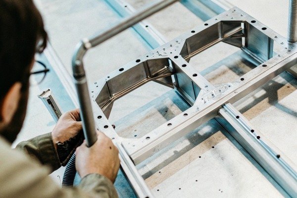 Technician assembling metal parts on table (ID#4)