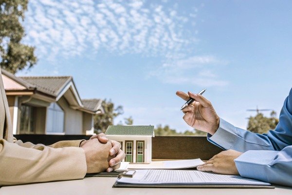 People discussing house model and contract outdoors (ID#5)