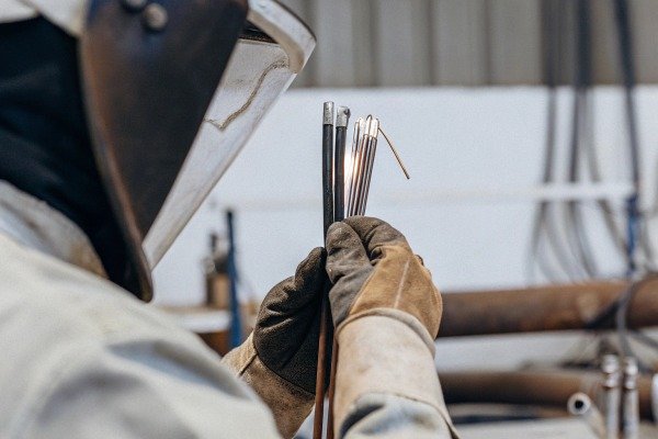 Welder holding electrodes with gloves (ID#2)