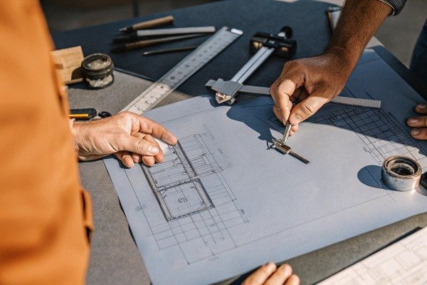 Hands working on architectural blueprint (ID#4)