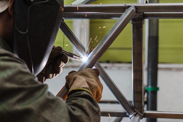 Welder working on metal frame with sparks (ID#3)