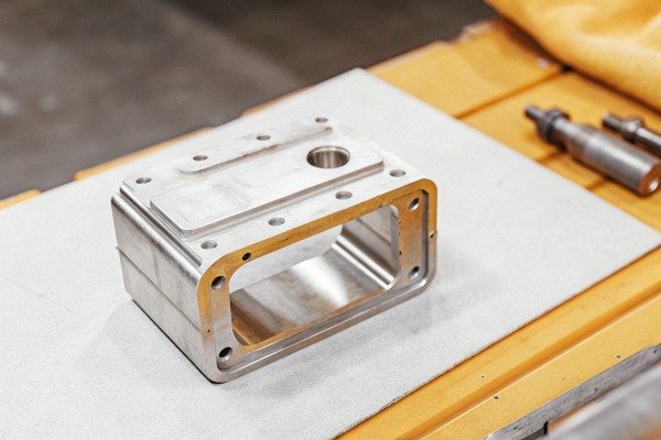 Precision metal component on workbench (ID#5)