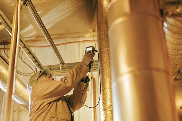Technician inspecting pipes with device (ID#4)