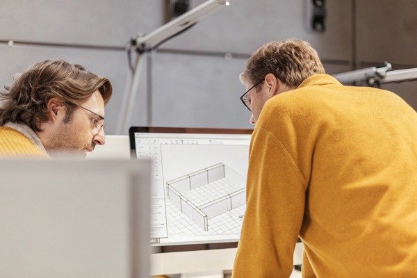 Two engineers discussing 3D model on computer screen (ID#5)