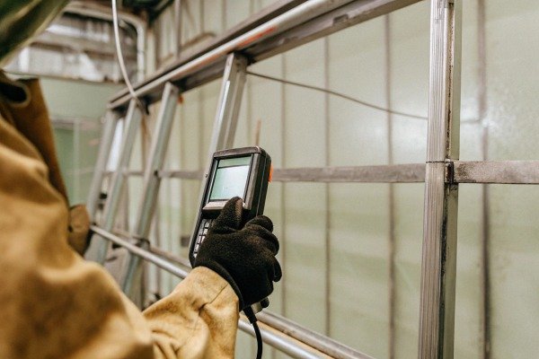 Рабочий с портативным устройством на металлической раме (ID#2)