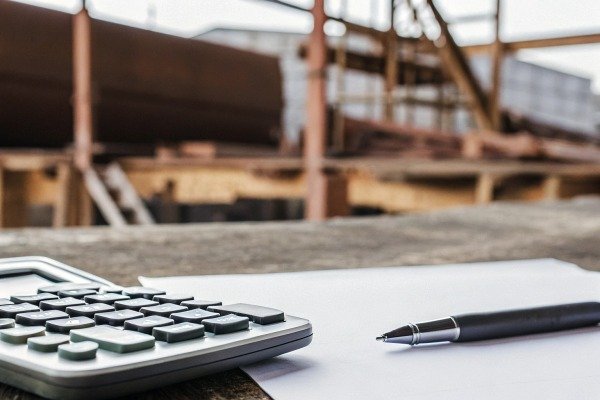 Calculator and pen on paper at workbench (ID#2)