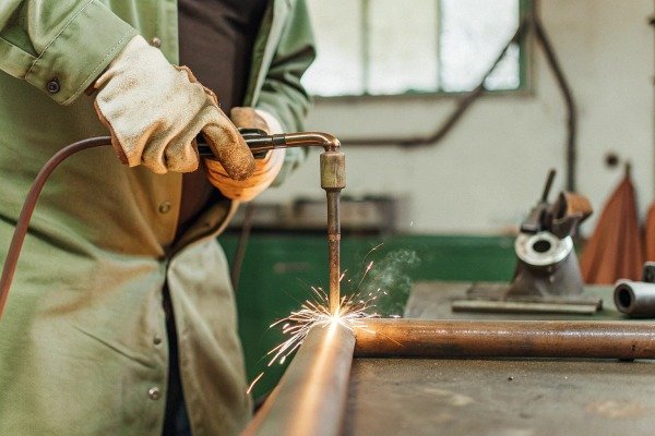 Worker welding metal pipe with sparks (ID#4)