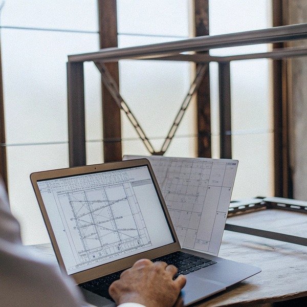 Person working on architectural plans on laptop (ID#1)