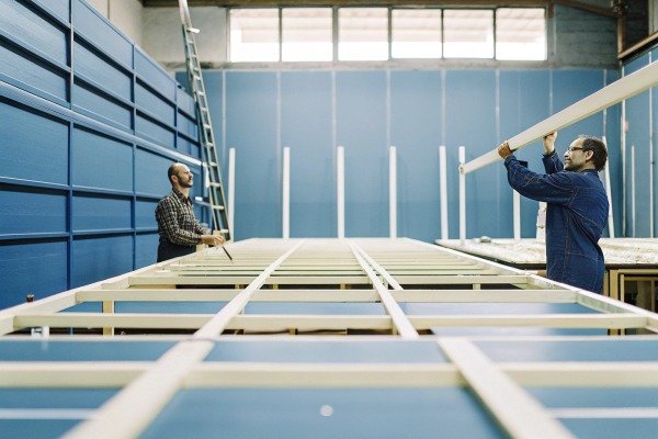 Two workers assembling metal structure indoors (ID#4)