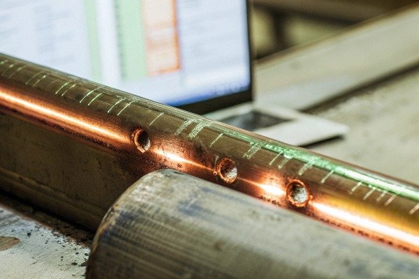 Close-up of copper pipe with drilled holes (ID#4)