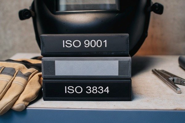 Stacked ISO certification books with gloves (ID#2)