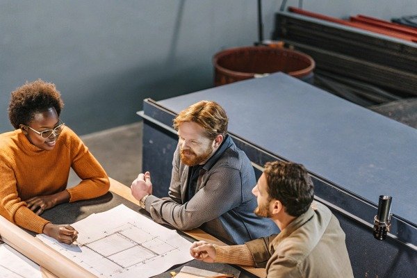 Team discussing construction blueprints indoors (ID#5)