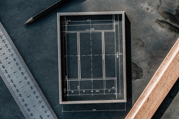 Blueprint and ruler on dark work surface (ID#4)