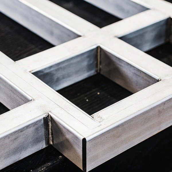 Close-up of metal frame structure on black surface (ID#1)