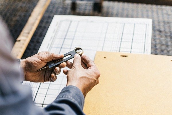 Hands measuring metal part with tool (ID#3)