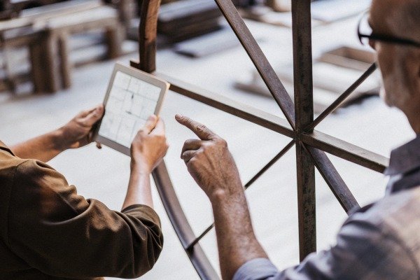 Workers discussing plans using tablet in factory (ID#4)