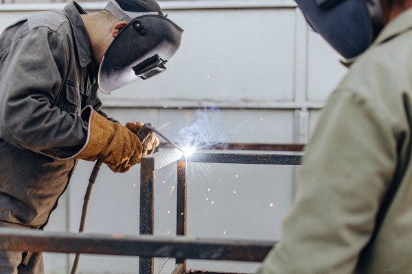Welder working on metal frame with sparks (ID#3)
