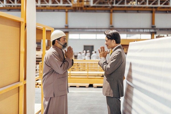Two men greeting with hands in warehouse (ID#5)