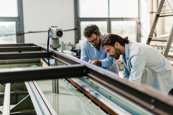 Engineers inspecting metal frame structure indoors (ID#5)