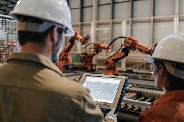 Engineers monitoring robotic arms on tablet (ID#5)