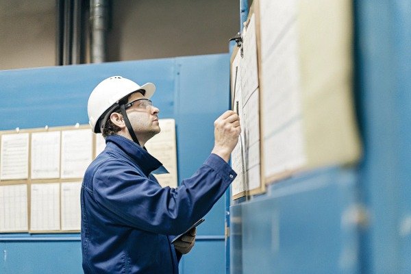 Worker inspecting control panel in factory (ID#2)